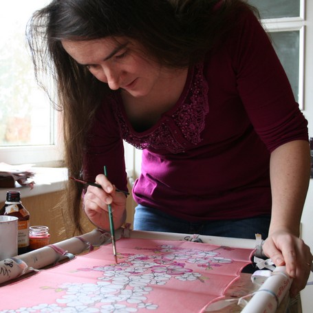 Elizabeth Grinberga painting silk scarf in her studio